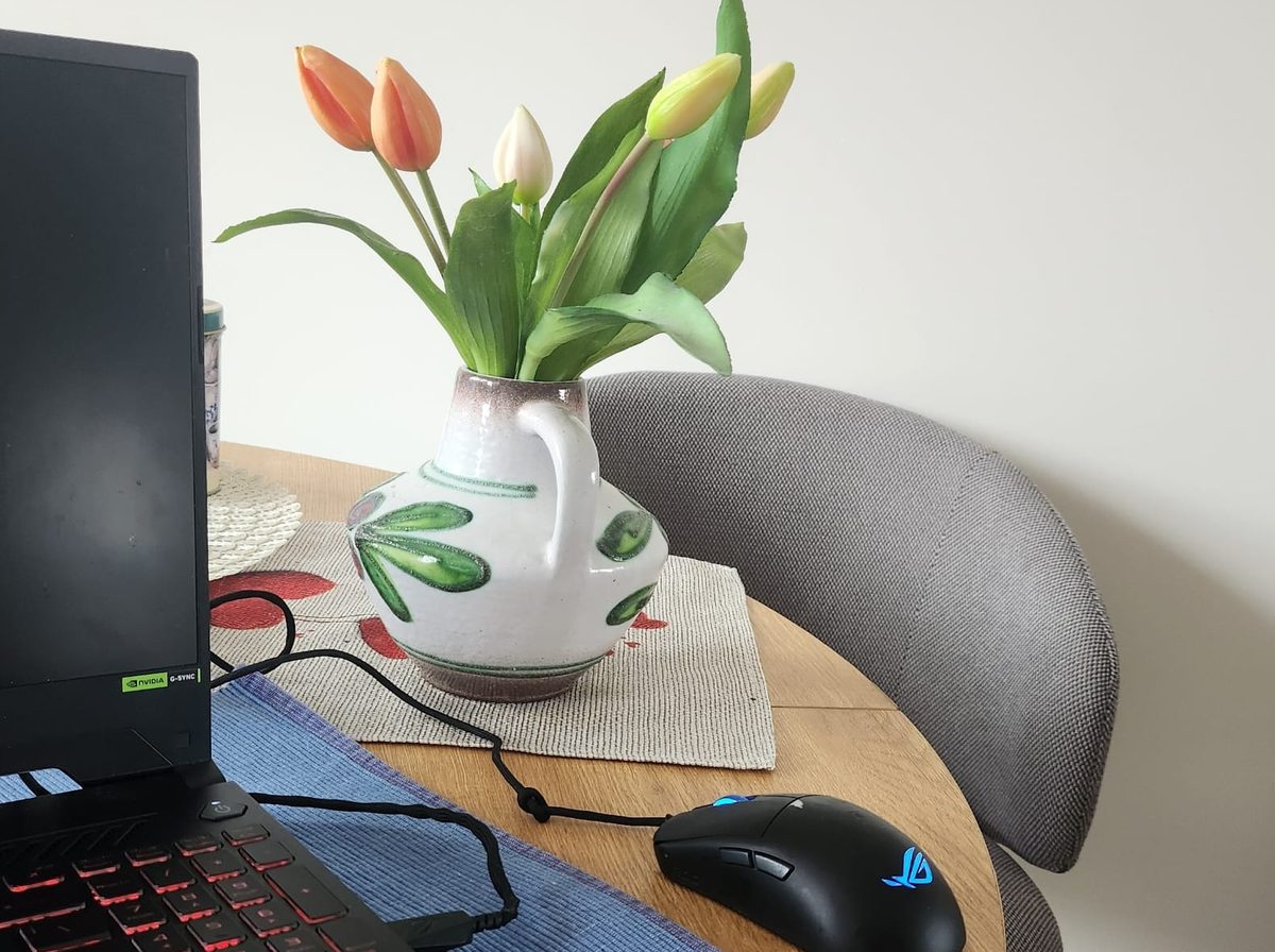 Stanowisko pracy w biurze WroTranslate: laptop na stole, obok bukiet tulipanów
